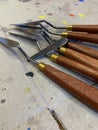 Closeup of isolated spatulas, painting tools on a cardboard background with drops of colored paint on an art lab