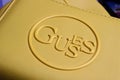 Closeup of isolated yellow purse with logo lettering of guess fashion company