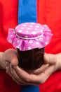 Closeup of jam jar held by hypermarket employee