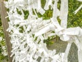 Closeup of Japanease Omikuji random fortunes paper tied to rope wire for good luck