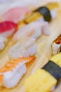 Closeup on Japanese ebi shrimp and tamagoyaki grilled egg sushi with other seafood pieces of rice hand-pressed nigirizushi Royalty Free Stock Photo