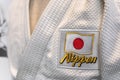 Closeup on a Japanese Judo uniform adorned with Japan national flag and word Nippon. Royalty Free Stock Photo