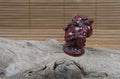 Closeup of japanese netsuke figure on wooden and bamboo background. japanese god mascot