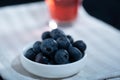 Closeup of a jar of blueberries ona kitchen towel. A glass of blueberry juice in the background Royalty Free Stock Photo