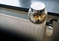 Closeup of a jar full of coins on a heating radiator Royalty Free Stock Photo