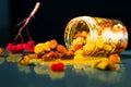 Closeup jar of honey mixed with nuts and rowan berries spilled on a reflective surface on black background Royalty Free Stock Photo