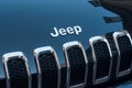 Closeup of Jeep logo on black car front parked in the street