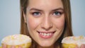 Closeup joyful woman eating donut with big appetite on grey background. Royalty Free Stock Photo