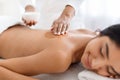 Joyful indian lady having skin scrubbing procedure at spa Royalty Free Stock Photo