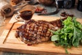 Juicy cooked cowboy steak with sauce and salad