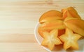 Closeup of Juicy Fresh Ripe Starfruit`s Cross Sections with Whole Fruit on Wooden Table