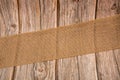 Closeup of a jute natural sack cloth strip roll on a wooden surface