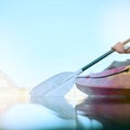 Closeup of kayak oar paddle rowing on calm water. Female hands kayaking on a lake during summer break. Woman outside in Royalty Free Stock Photo