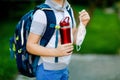 Closeup of kid boy, medical mask, water bottle and backpack or satchel. Schoolkid on way to school. child outdoors. Back