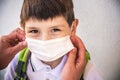 Closeup Kid face wearing protective face mask for pollution or virus, Cropped shot of school boy wearing protection mask against Royalty Free Stock Photo