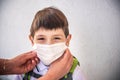 Closeup Kid face wearing protective face mask for pollution or virus, Cropped shot of school boy wearing protection mask against Royalty Free Stock Photo