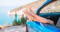 Close up of little girl feet showing from car window background sea Royalty Free Stock Photo