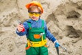 Closeup kid in orange helmet holding hammer in his hands. Crafts lesson at kindergarten. Portrait of little boy in Royalty Free Stock Photo