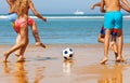 Closeup of kids legs play soccer on the sea beach Royalty Free Stock Photo