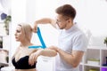 Closeup kinesiology taping. Physical doctor therapist applying kinesio tape to patient shoulder athlete woman Royalty Free Stock Photo