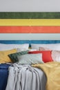 Closeup of king size bed with green, yellow, red and grey pillows Royalty Free Stock Photo