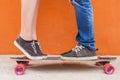 Closeup kissing couple at skateboard and red wall background