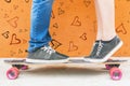 Closeup kissing couple at skateboard and red wall background