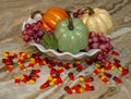 Closeup of  Kitchen counter with three Faux Decorative Pumpkins with grapes and Candy Corn Scattered around base Royalty Free Stock Photo