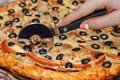 Closeup of knife cutting pizza