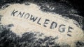 Closeup of KNOWLEDGE text written on white sand Royalty Free Stock Photo