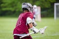 Closeup of a lacrosse player running in a sports field