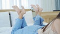 Closeup of lady girls feet up movement, laying down on bed in bedroom at home. People relaxing lifestyle