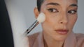 Closeup lady powdering face using brush home. Woman applying foundation makeup Royalty Free Stock Photo
