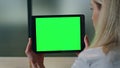 Closeup lady watching greenscreen tablet at office. Woman hands holding computer