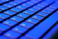 Closeup of laptop keyboard illumination with a red and blue light on it. Royalty Free Stock Photo