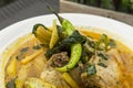 Closeup of a large chili known as siling mahaba on top of Chicken Tinola, a Filipino soup dish