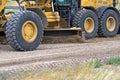 Closeup of large roadgrader wheels at work. Royalty Free Stock Photo