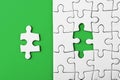 Closeup of the last piece of puzzle missing on green background Royalty Free Stock Photo