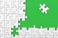 Closeup of the last piece of puzzle missing on green background Royalty Free Stock Photo
