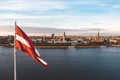 Closeup of the Latvian flag waving in the air with the old town of Riga, Latvia in the background Royalty Free Stock Photo