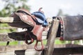 Horse saddle hanging on a wooden fence Royalty Free Stock Photo