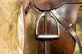 Closeup leather cowboy saddles hanging on the railing