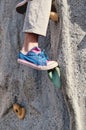 Closeup of leg and tennis shoe on rock climbing wall