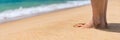 Closeup on leg of young woman standing on sea shore. Woman legs and feet walking on the sand of the beach with the sea water in Royalty Free Stock Photo