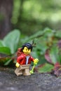 Closeup of a Lego minifigure of a hiker male on a rocky surface against the blurry background