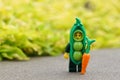 Closeup of a Lego minifigure in a pea costume holding a carrot