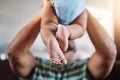 Closeup, legs and baby with father, love and playing with joy, happiness and bonding in the lounge. Zoom, dad and infant Royalty Free Stock Photo