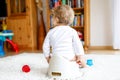 Closeup of legs of cute little 12 months old toddler baby girl child sitting on potty. Royalty Free Stock Photo