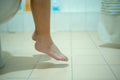 Closeup legs and feet of child siting and peeing in toilet