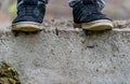 Closeup of Legs of Guy Standing on the Edge of Concrete Block, Symbolizing the Big Leap, Decision Making Loneliness, Sadness Royalty Free Stock Photo